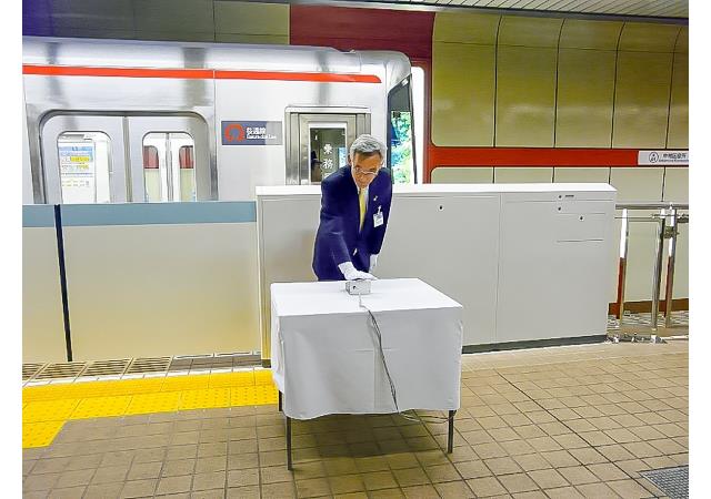 中村区役所駅で行ったホーム柵使用開始式でスイッチを押す様子